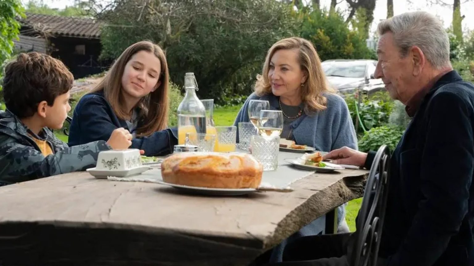 Quatro pessoas à mesa ao ar livre em cena de divulgação do filme Querendo ou Não.