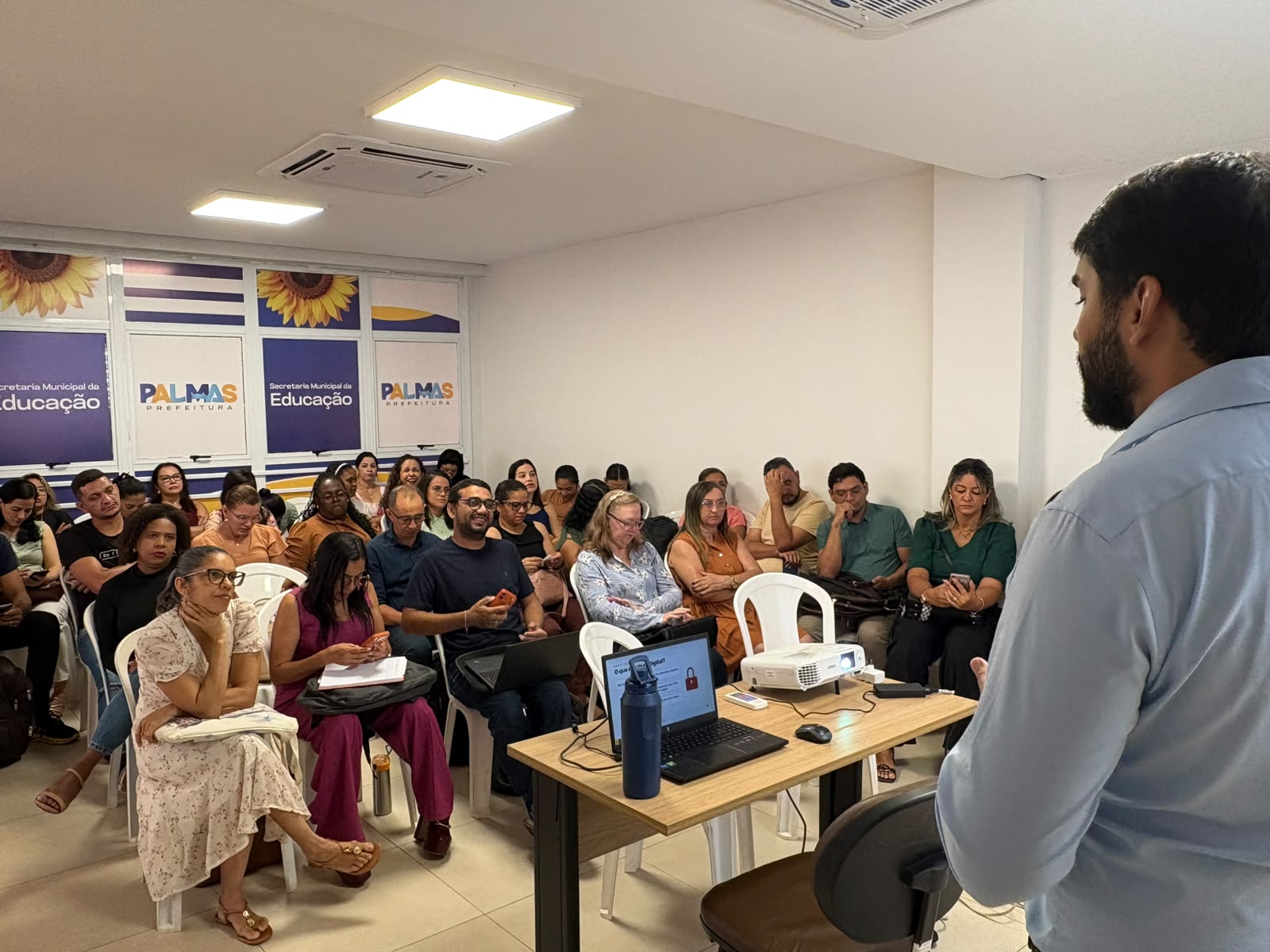 Formador conduz apresentação para grupo de adultos em sala da Secretaria Municipal da Educação de Palmas.